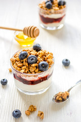 Fitness breakfast with muesli, honey and berries on white table