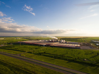 a huge concrete plant with pipes among the fields. aerial view