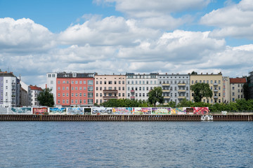 River Spree, graffiti wall and apartment buildings in Berlin, Friedrichshain