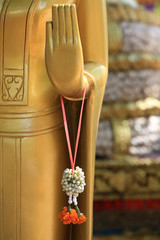 Bouddha. Colliers compos&eacute;s d'oeillets oranges et de jasmin. Offrandes. Wat Simuong. Wat Si Muang. Vientiane. Laos.