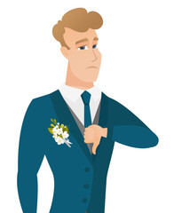 Disappointed caucasian groom with thumb down.