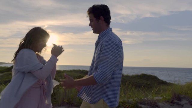 Playful Couple Dance And Kiss On The Beach At Sunset