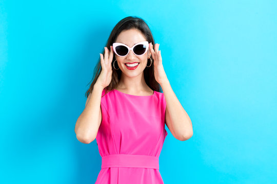 Young woman with sunglasses on a blue background