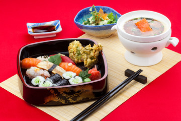 Sushi Set: sashimi and sushi rolls on red background