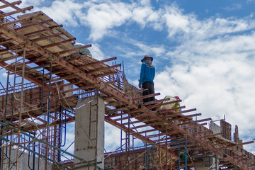 Workers at the construction site and the sky