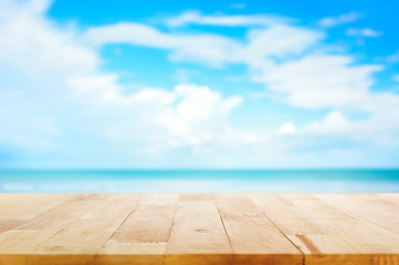Wood table top on blur blue sea and sky background