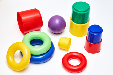 Colourful round children toys and colourful plastic glasses on white background