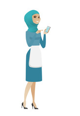 Young muslim cleaner holding a mobile phone.
