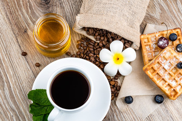 Cup of coffee and pastry on wooden background