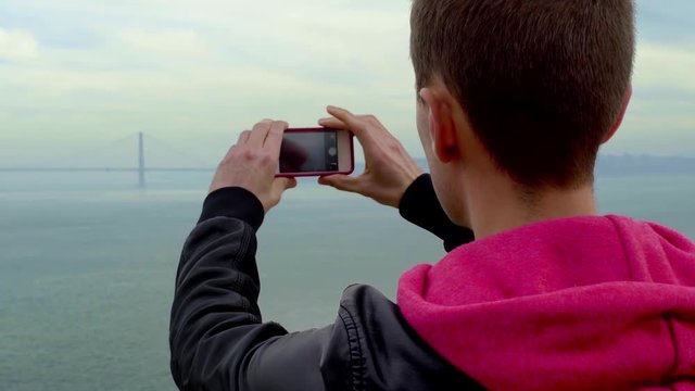 Tourist Takes A Photo Of The Golden Gate Bridge In The Distance (Slightly Foggy Out)