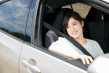 young woman sitting on assistant seat of motor vehicle.