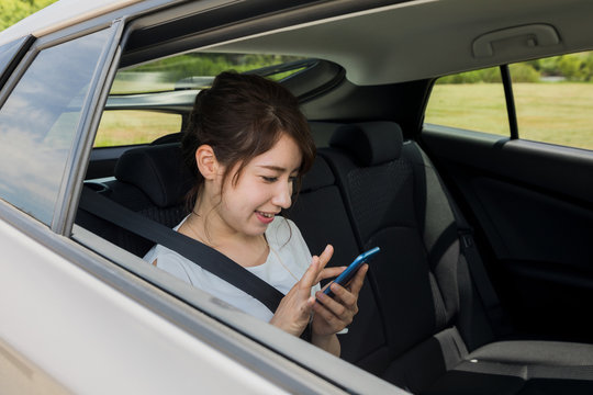 young woman using smart phone in the car.