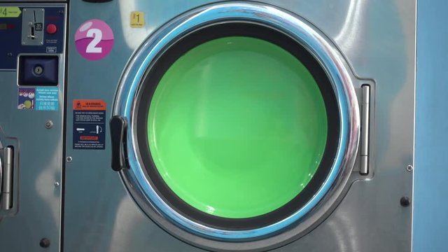 Household appliance - a side loading washing machine spinning in wash cycle at a laundromat