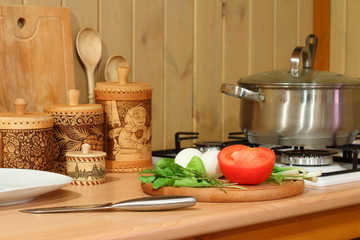 Fresh vegetables and greens on the kitchen table in the cooking process.
