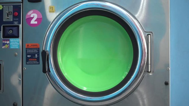 Household appliance - a side loading washing machine spinning in wash cycle at a laundromat