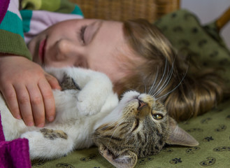 Little girl and cat are relaxing.