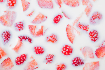 Background of a strawberry pieces in the milk. Sweet dessert. Healthy eating.