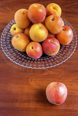 Naklejka na ściany i meble Fresh ripe apricots on plate on wooden background closeup