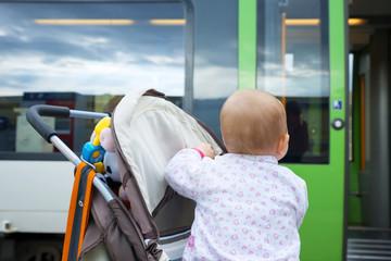 little cute baby looks at the closing door of the train