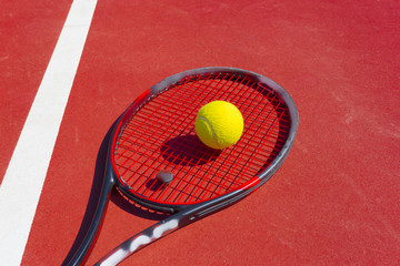 Tennis balls and racket on the grass court