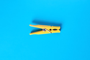 Yellow clothespin on blue background