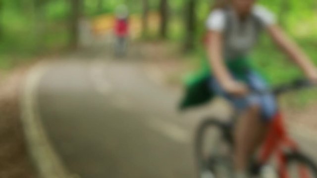 Out of focus video of people bicycling on bicycle path