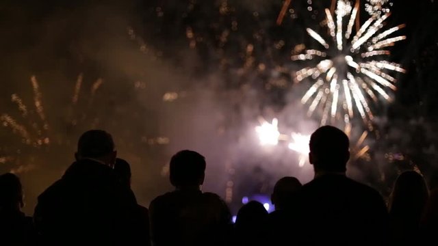 Silhouettes of people watching fireworks