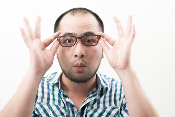 Portrait of young handsome man isolated on white background touching his glasses.
