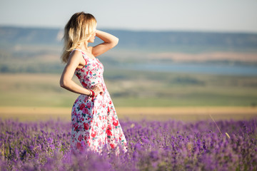 Beautiful girl is walking on the lavender field