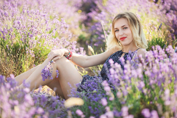 Beautiful young woman lying on the lavender field