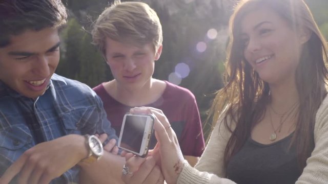 Teen Girl Shows Her Friends Photos, From Their Adventure, On Her Phone (Slow Motion) 