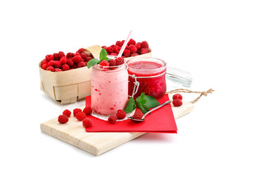 Raspberry smoothies, raspberry jam and a basket with ripe raspberries on a white background.