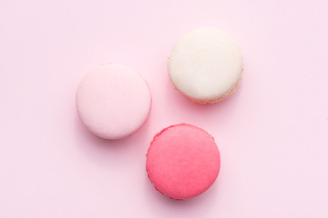 Tasty pink cake macaron or macaroon on pink background from above