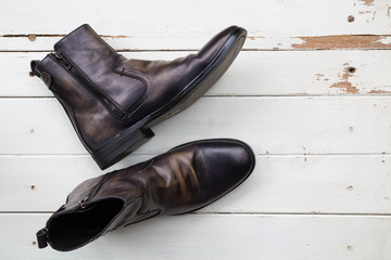 Leather boot  on old white wooden background
