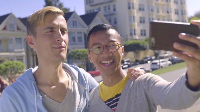 Fun Gay Couple Take Silly Selfies Together In Front Of Historic Painted Ladies In San Francisco