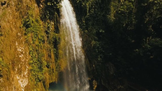 Beautiful waterfall in green forest in jungle. Aerial view:tropical rain forest with waterfall.Waterfall with natural swimming pool in a mountain river canyon. Philippines, Cebu. 4K video. Travel