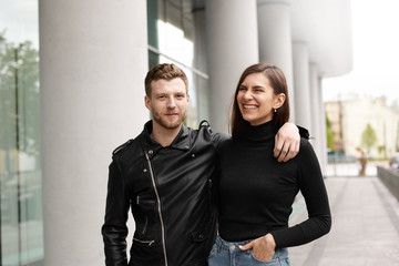 Outdoor shot of charming girl laughing out loud, having fun on first date with charismatic good-looking guy. Cute young European couple walking on city streets, enjoying each other's company