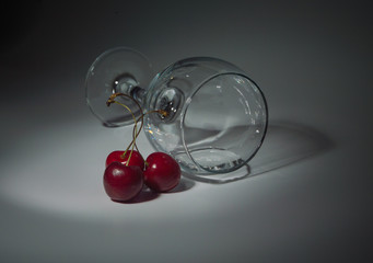 closeup of a glass with water and cherry blossoms on a white background.
