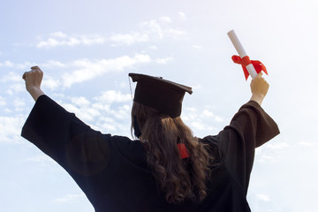 Graduate put her hands up and celebrating with certificate in her hand and feeling so happiness in Commencement day. Toned