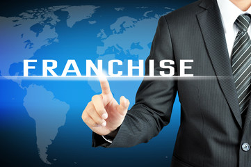 Businessman hand pointing on FRANCHISE sign on virtual screeen