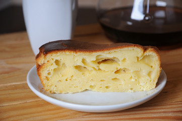 A piece of curd cake close-up. Coffee in the background