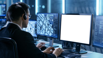 Professional IT Engineers Working in System Control Center Full of Monitors and Servers. Possibly...