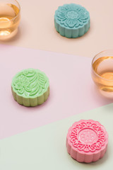 Sweet color of snow skin mooncake. Traditional mid autumn festival foods with tea on table setting.
