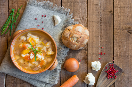 Vegetable soup with bread on wood