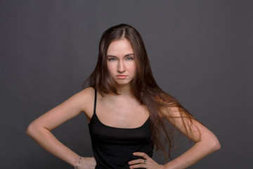 Fototapeta premium Angry woman with hands on hips looking at camera