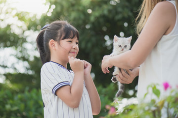 Obraz premium mother giving a kitten to her daughter