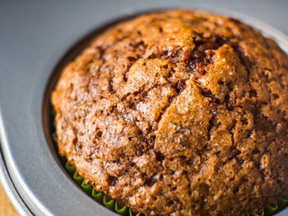 Banana chocolate muffins with caramel sugar topping on dark background