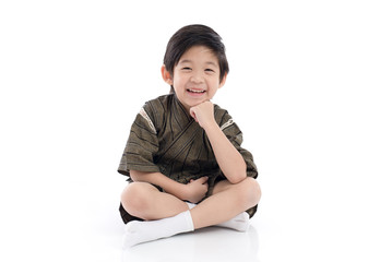 Happy asian boy in kimono sitting