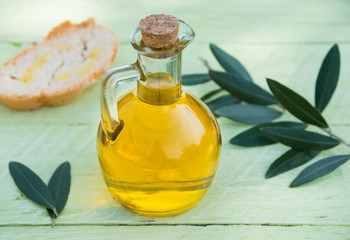 Olive oil in a bottle with olive Leaves and bread