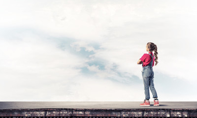 Concept of careless happy childhood with girl looking far away